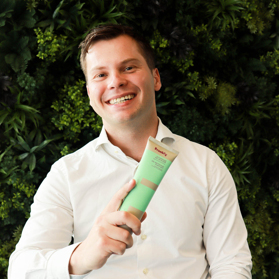 Max met een tube Zuiverende Gel Reiniger voor een wand vol planten